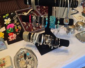 A few pieces of jewelry have been sold off the silver platter and black rack.