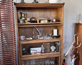 Vintage glassware, stemware, lamps, brass pieces, mugs, crystal, small boxes, and layered shelf finds.