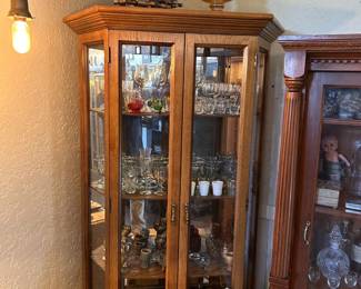 Vintage glassware shown in display, including stemware, goblets, decanters, colored glass, cups, and assorted glass pieces.