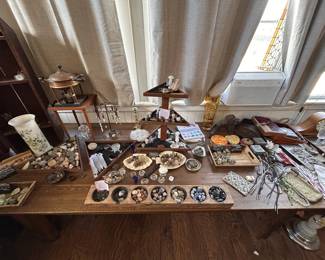 A layered table of minerals, shells, glass vessels, candlesticks, jewelry pieces, trays, boxes, and antique-shop smalls.