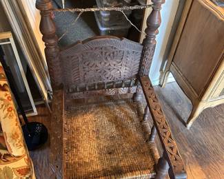 Selected carved wooden chair with woven cane/rush-style seat and detailed carved woodwork.
