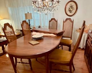 Vintage French Provincial style dining room set; large oval extendable wooden table with six upholstered cane-back chairs