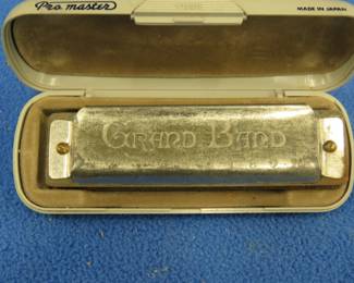 Lot 410. Suzuki Grand Band 10-hole diatonic harmonica in the key of C in a plastic case with poor sound.