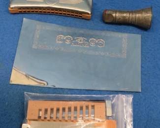 Lot 81. Harmonica collectibles: Unassembled NIP Hohner harmonica parts. An unidentified harmonica with fair sound. An old two-hole tin noisemaker horn that works.
