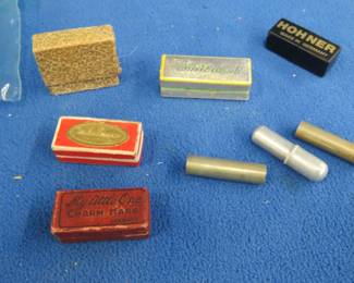Lot 356. Harmonica smalls: Five empty boxes for miniature harmonicas from or for Jackie Cogan, My Little One Charm Harp, Chr. A. Essbach, Hohner, and unknown. Three one-note pitch pipes C and two A's