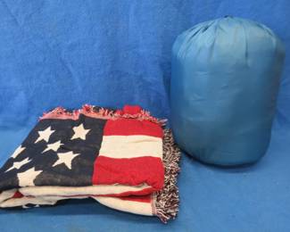 Lot 328. American flag throw blanket 72" X 56" and a Eureka Minnow sleeping bag. Both in a backpack style carrying case.
