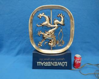Lot 454. Working Lowenbrau sign. Double-spinning and lighted ceiling mount advertising piece. Damage as pictured, and one missing letter.