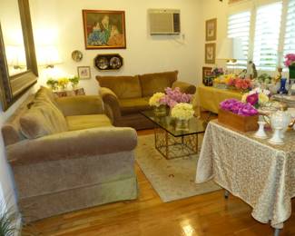 Sofa & loveseat, glass top brass base coffee table, lots of bric-a-brac, framed art, decorative wall hangings