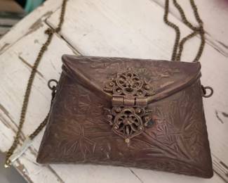 metal purse with ornate filigree clasp and chain strap