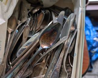 Silverware and a couple of silver plated serving plates
