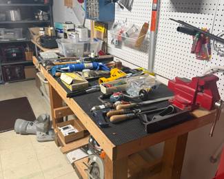 Tool bench. One with wood vice on left side and red vice is separate. Miscellaneous tools