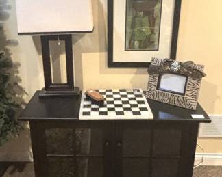 Black cabinet, lamp. Chess board.
