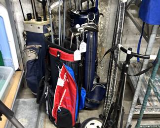 Various golf clubs, golf bags, golf walking cart.