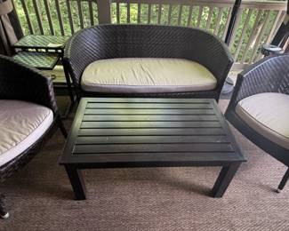 Wicker chairs and loveseat with cushions. Metal coffee table.