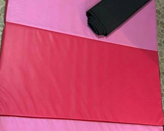 Lot 25: Pink and red folding gym mat with carrying strap