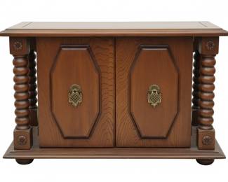 early 20th-century Jacobean Revival music cabinet features a sturdy oak construction with distinctive spiral-turned legs and ornate brass hardware.
