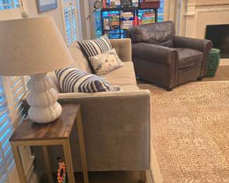 couch and comfy leather chair, occasional tables, variety of lamps and home decor