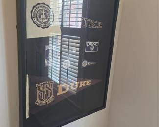 collection of DUKE pennants in a shadow box frame