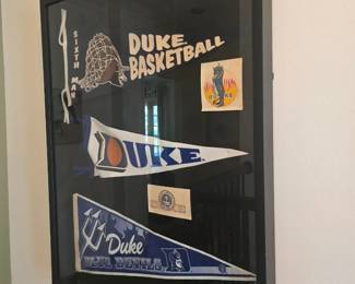 collection of DUKE pennants in a shadow box frame