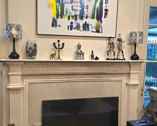 above the fireplace is a painting by George Bibb, and leaning against the fireplace is a large 55" Samsung LED Smart TV.