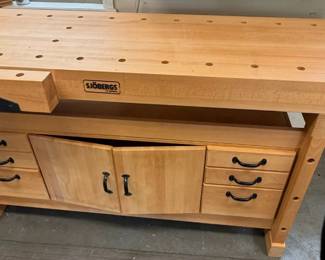 Sjobergs of Sweden Woodworking Workbench w/ Dual Vises & Storage Heavy-duty Sjobergs of Sweden woodworking bench featuring a solid work surface with bench dog holes, dual built-in vises, drawers, and cabinet storage. Quality European woodworking bench designed for workshop and hobby use.  Sjobergs of Sweden woodworking bench Solid wood construction Two built-in vises Multiple bench dog holes across top surface Includes storage drawers and lower cabinet Cabinet doors currently tacked shut to keep pieces together; can be adjusted to close properly Ideal for woodworking, carving, hobby, and workshop use Shows light shop wear from use Measurements:  Approx. 73 3/4" L Approx. 26 1/2" W Approx. 35 1/2" H Market Insights: Sjobergs woodworking benches are highly regarded among woodworkers for their durable European construction and workshop functionality. Larger bench models with storage and dual vises like this commonly fall in the $500–1,000 range based on current market trends. 