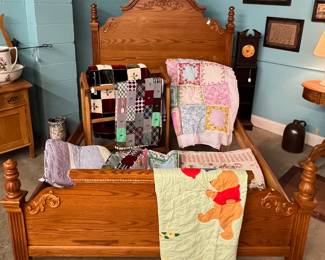 Oak bed and many quilts and comforters