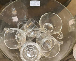 Lot 56: Clear glass teacups with saucers, champagne flute, decanter, and pink hydrangea centerpiece