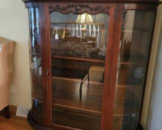 Antique bow front China with wavy glass.