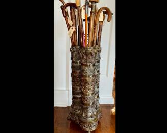 Antique Victorian brass repousse triple umbrella stand with handle, on paw feet.