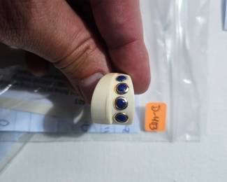 Potential Bone or Ivory ring w/ blue stones in gold embezel setting; one of the gold-tone embezel setting is missing