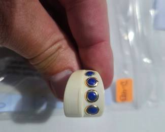Potential Bone or Ivory ring w/ blue stones in gold embezel setting; one of the gold-tone embezel setting is missing