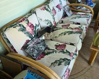 This is a vintage Ficks Reed or Paul Frankl style rattan 'pretzel' sofa with a tropical print