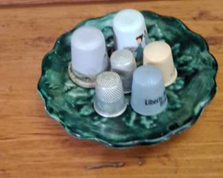 Collection of Assorted Thimbles on a Green Art Pottery Dish
