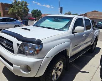 B‑I‑G Loaded • Variety*Toyota Tacoma (Double Cab)** - Make: Toyota - Model: Tacoma - Trim: TRD (TRD badge visible on side) - Color: Super White - Cab: Double Cab - Hood: Scoop with bug deflector/hood guard - Wheels: TRD alloy wheels - Tires: All-terrain - Running Boards: Side steps - Tinted Windows: Yes - Sunshade: Windshield sunshade present - Paint Condition: Good - Registration: New Mexico - Year: TBD - VIN: TBD - Miles: TBD - Engine: TBD - Transmission: TBD - 2WD/4WD: TBD