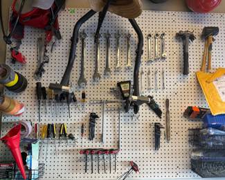 Assorted motorcycle tools, rear stand for track bike, pegboard accessories 