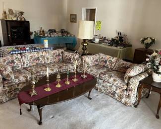 Here we have a sofa and loveseat with matching fabric, an elegant set of candlestick holders, and oval coffee table.