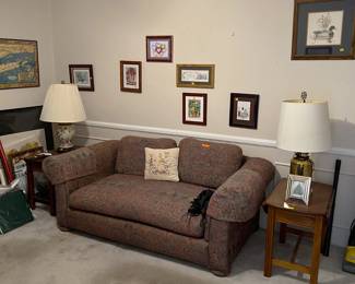 This loveseat is calling for you to come sit for a while. Enjoy the side tables, the lamps, and the artwork on the walls.
