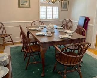 This dining table has eight matching chairs and at least one table leaf for larger dinner parties.