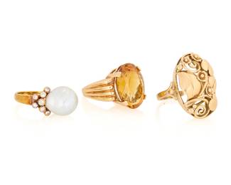 1102 A Group of Three 14K Gold Rings Featuring a baroque cultured pearl, an oval citrine and one of a scrolling floral design 3 pieces Sizes: 6, 7 3/4 and 8 1/2 31.3 grams gross This lot is being offered with no reserve Estimate: $2,000 - $3,000