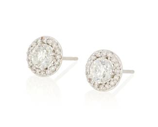 1045 A Pair of White Gold and Diamond Stud Earrings Centering two round diamonds weighing approximately 0.65 carat each, encircled by round diamonds 2 pieces Measures: 3/8 in. 1.8 grams gross This lot is being offered with no reserve Estimate: $500 - $700