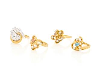 1151 A Group of 18K Gold and Diamond Rings All of swirling designs accented by round near colorless diamonds, round and pear-shaped orange diamonds and an oval blue diamond 4 pieces Sizes: 5 3/4, 6 1/4, 7 1/2 and 7 3/4 37.3 grams gross Estimate: $3,000 - $5,000
