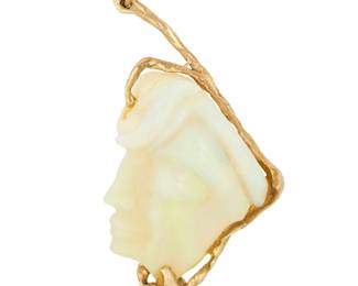 1098 A 14K Gold and Opal Pendant Of an organic design featuring a carved opal of a woman's profile measuring approximately 40.00 x 30.00 x 6.27 mm Measures: 2 1/2 X 1 1/4 in. 16.0 grams gross Estimate: $1,000 - $1,500
