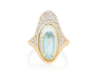 1129 Erte: A 14K Gold, Gem-Set and Diamond Ring Centering an oval blue topaz set in a carved mother-of-pearl element accented by round diamonds, signed Erte, CFA Size: 5 1/2 6.8 grams gross This lot is being offered with no reserve Estimate: $500 - $700