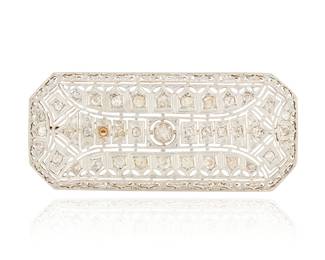 1053 A Platinum Topped-Gold and Diamond Brooch Of a geometric openwork design featuring old mine-cut diamonds weighing approximately 3.00 carats Measures: 2 1/2 x 1 1/8 in. 15.1 grams gross This lot is being offered with no reserve Estimate: $1,200 - $1,800
