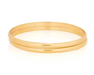 1062 Two 22K Gold Bangles Of a high polish design Inner circumference: 7 3/4 in. 33.8 grams gross Estimate: $3,500 - $4,500
