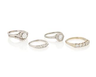 1041 A Group of White Gold, Platinum and Diamond Rings Including a solitaire diamond ring, a five stone diamond ring, four stone baguette diamond ring and a round diamond wedding set 5 pieces Size: 5 1/2, 6, 9 18.4 grams gross Estimate: $1,200 - $1,500