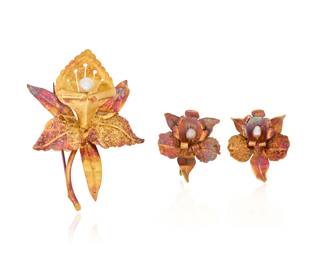 1099 An 18K Gold and Pearl Brooch and Earring Set Of an orchid design centering seed pearls 3 pieces Brooch: 2 1/4 x 1 3/4 in., Earrings: 3/4 in. 16.7 grams gross This lot is being offered with no reserve Estimate: $1,500 - $2,500