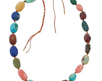 1027 An 18K Gold and Hardstone Bead Necklace Featuring rough faceted stones of rhodochrosite, labradorite, ruby, lapis lazuli, azurmalachite, turquoise, amazonite, aquamarine and peridot, finished with an 18k gold circle clasp Length: 19 in. 92.8 grams gross This lot is being offered with no reserve Estimate: $500 - $700