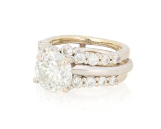 1049 A 14K White Gold Diamond Ring Wedding Set Centering around diamond weighing approximately 2.48 carats, together with a jacket featuring two bands of round set diamonds in a chevron design 2 pieces Size: 4 3/4 and 5 8.3 grams gross center diamond I-J, I2-I3 Estimate: $2,500 - $3,500