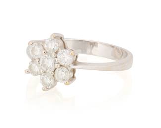 1046 An 18K White Gold and Diamond Ring Of a flower design featuring seven round diamonds weighing 0.65 carat Size: 5 1/2 2.7 grams gross Estimate: $1,000 - $1,500